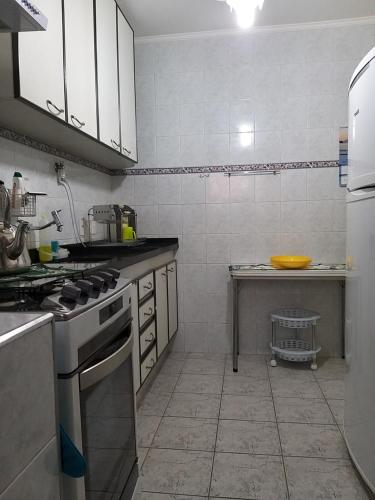 a kitchen with a stove top oven in a kitchen at Apartamento Praia Massaguaçú in Caraguatatuba