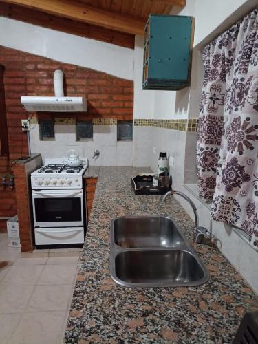 a kitchen with a sink and a stove at Lo de Nelly in Puerto Madryn