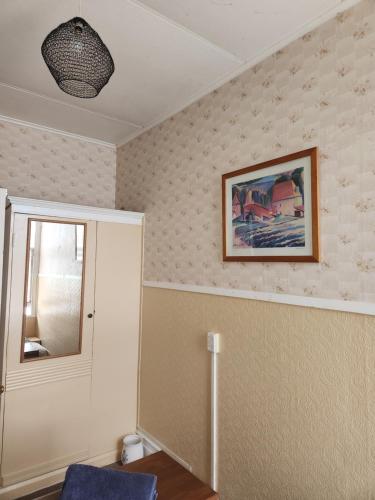 a room with a mirror and a picture on the wall at Quirky Villa Homestay in Whanganui