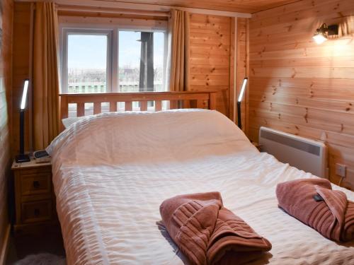 a bedroom with a bed in a wooden room at Algwen Cabin 