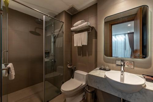 y baño con aseo, lavabo y ducha. en Thanh Long Hotel - Tra Khuc, en Ho Chi Minh
