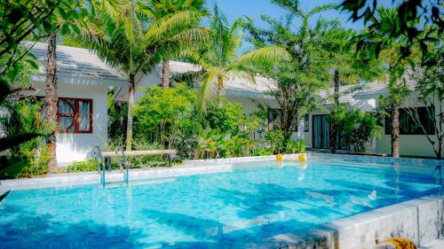 a swimming pool in front of a house with trees at Nainan resotel ในน่าน รีโซเทล in Nan