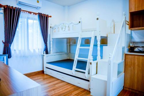 a white bunk bed with a ladder in a room at Nainan resotel ในน่าน รีโซเทล in Nan