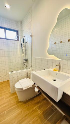 a bathroom with a tub and a toilet and a sink at Nainan resotel ในน่าน รีโซเทล in Nan
