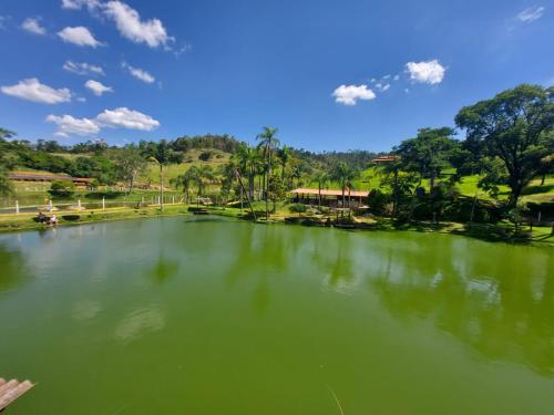 a large pond with green water in a park at Apartamento Aconchegante Centro Serra Negra in Serra Negra