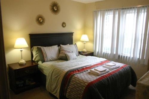 a bedroom with a bed with two lamps and towels on it at Close to Falls, Steps to Casino, Sleeps 7-8 in Niagara Falls