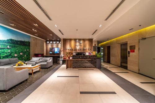 a lobby of a hotel with couches and a table at Thanh Long Hotel - Tra Khuc in Ho Chi Minh City