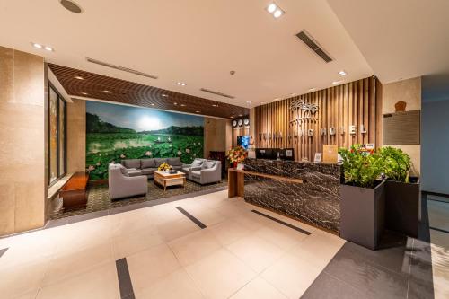 a lobby of a hotel with a couch and chairs at Thanh Long Hotel - Tra Khuc in Ho Chi Minh City