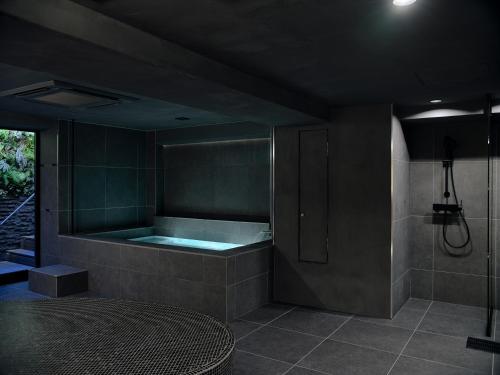 a bathroom with a bath tub with a sink at Sakura Cross Hotel Kyoto Kiyomizu in Kyoto