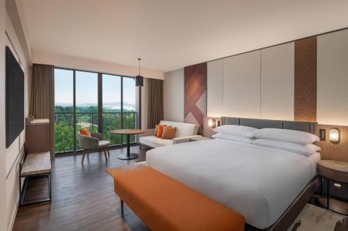 a hotel room with a large bed and a large window at Palm Garden Hotel, Putrajaya, a Tribute Portfolio Hotel in Putrajaya