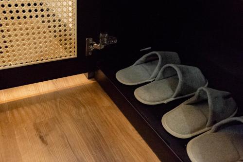 a pair of shoes sitting on the floor next to a wall at Cozy An Boutique Hotel Luangprabang in Luang Prabang