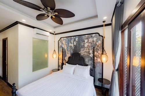 a bedroom with a bed and a ceiling fan at Cozy An Boutique Hotel Luangprabang in Luang Prabang