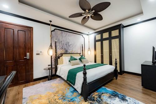 a bedroom with a bed and a ceiling fan at Cozy An Boutique Hotel Luangprabang in Luang Prabang