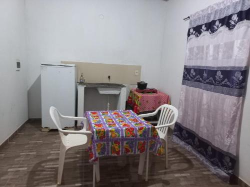 a kitchen with a table and two chairs and a table with a blanket at HOSPEDAJE 3 de Mayo in Encarnación