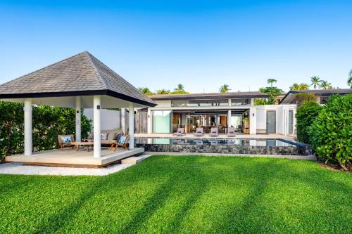 a house with a lawn and a gazebo at Twin Villas Natai North - 5 Bedroom Luxury Beach Front Villa in Natai Beach