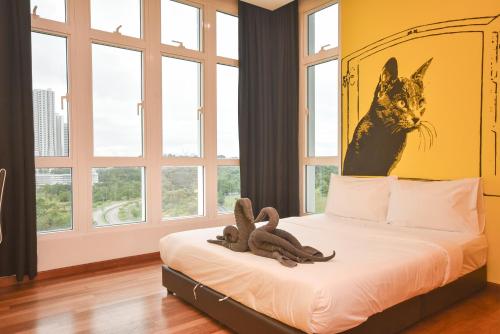 a bedroom with a bed with a cat painting on the wall at 1Medini Theme Suite by Nest Home【LEGOLAND】 in Nusajaya