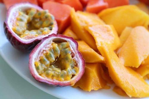 a plate of fruit with passion fruit and orange slices at Nine Arch View Ella in Ella