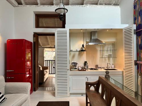 ein Wohnzimmer mit einem roten Kühlschrank und eine Küche in der Unterkunft 1A Court Square by AQUA Villa in Galle