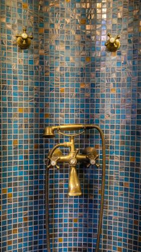 ein Badezimmer mit einer Dusche mit einem Messingfaucet in der Unterkunft 1A Court Square by AQUA Villa in Galle