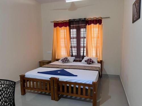 um quarto com 2 camas e uma janela em Anugraha Lotus Homestay em Varkala