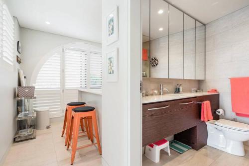 uma casa de banho com um lavatório, um WC e um espelho. em Balmoral Beach Beauty em Sidney