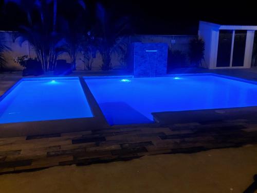 a swimming pool at night with blue lighting at Casas Doña Juanita in Jacó