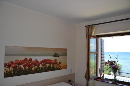 a painting of tulips on a wall next to a window at Locanda Le Palafitte in Bardolino