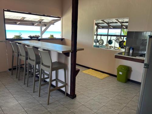 a bar in a kitchen with a view of the ocean at Rangiroa Bliss in Tiputa