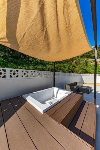 a bath tub sitting on a table under a umbrella at Sunrise Vista Nanjyo -SEVEN Hotels and Resort- in Nanjo
