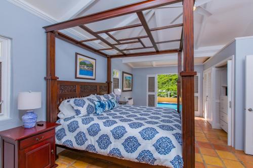 1 dormitorio con 1 cama con dosel de madera en Seaview Palms Villa - St Croix USVI, en Christiansted