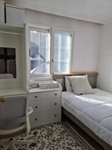 um quarto com uma cama, uma cómoda e uma janela em Sophie's House em Seul