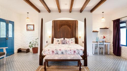 a bedroom with a bed with a wooden headboard and a table at Aphrodite Homestays Coorg by The Almanac in Napoklu