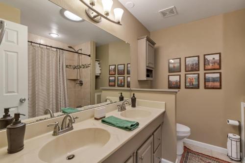 a bathroom with two sinks and a toilet at ᨒFIREHAUSᨒHotTubᨒCinemaᨒBBQᨒBadmintonᨒGames in Arvada