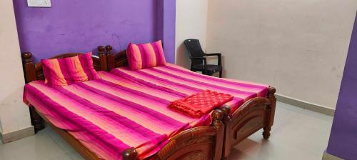 a large wooden bed with a pink blanket on it at OYO SRIVARI PREMIUM HOMESTAYS in Vellore