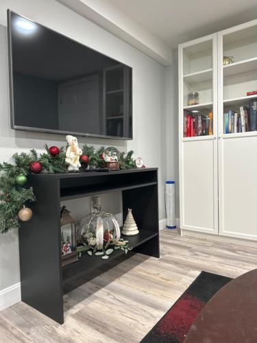 a living room with a black entertainment center with a tv at Cozy Finished Garden Level Bed+Bath in Dedham