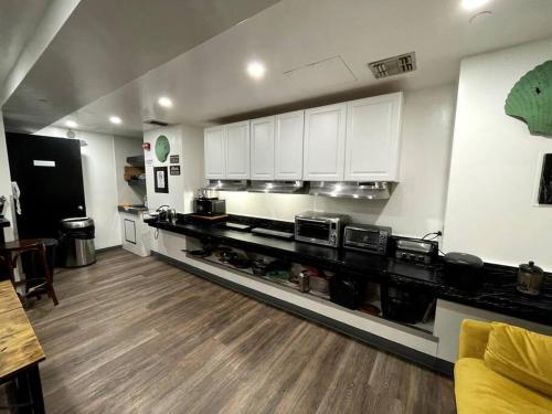 duża kuchnia z białymi szafkami i drewnianą podłogą w obiekcie Hotel-Studio @ The Mansfield Midtown w Nowym Jorku