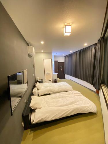 twee bedden in een ziekenhuiskamer met een spiegel bij ロマンスホテル（Romance Hotel） in Nakamachi