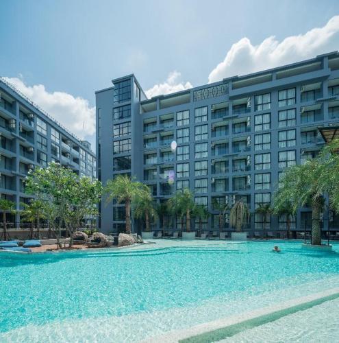 a large swimming pool in front of a large building at Kamala Beach P72 Exclusive Junior Suite in Bang Tao Beach