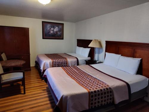 a hotel room with two beds and a chair at Shamrock Motel in Bellingham