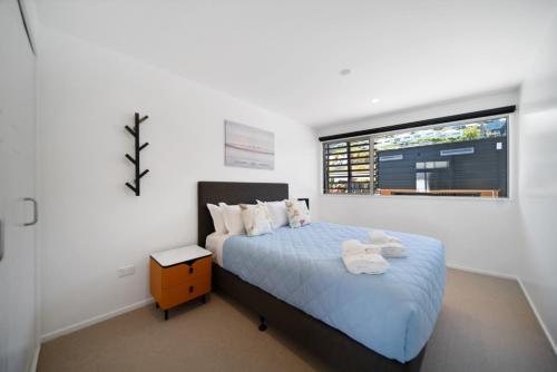 a bedroom with a blue bed with a window at Blackrock Apartments Queenstown in Queenstown