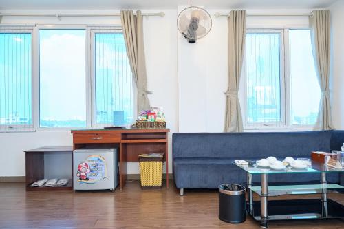 河內的住宿－A25 Hotel - 28 Trần Quý Cáp，客厅配有蓝色的沙发和桌子