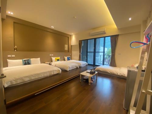 a bedroom with two beds and a large window at 觀關嚮戶民宿 臺東縣民宿1214號 in Guanshan