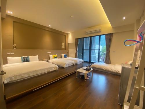 um quarto com 2 camas e uma grande janela em Guan Guan Xiang Hu em Guanshan