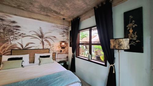 1 dormitorio con cama y ventana en La Plage Hotel en El Nido
