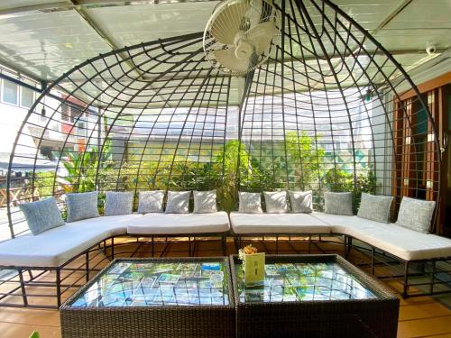 a bird cage with benches and a clock on top at Chinda Boutique Hotel - SHA Certified in Chiang Mai