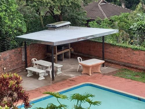 a picnic table and bench next to a pool at Rilli's Inn Studio in Mtunzini