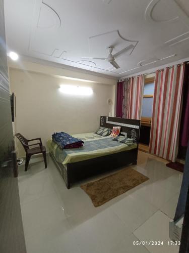 1 dormitorio con 1 cama y 1 silla en Hobbit, en Gurgaon