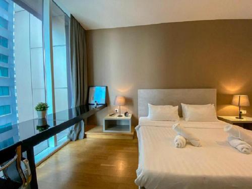 - une chambre avec un grand lit blanc et une fenêtre dans l'établissement Platinum Suites KLCC Kuala Lumpur Bukit Bintang by AR Hospitality, à Kuala Lumpur