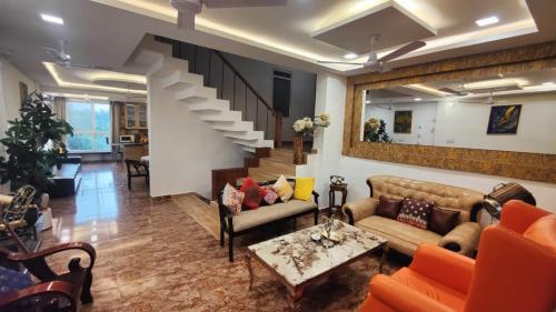 a living room with couches and a staircase at Richhariya Nature's Retreat Homes in Jhānsi
