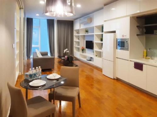 a living room with a dining table and a kitchen at PLATINUM Suites KLCC By AR Hospitality in Kuala Lumpur